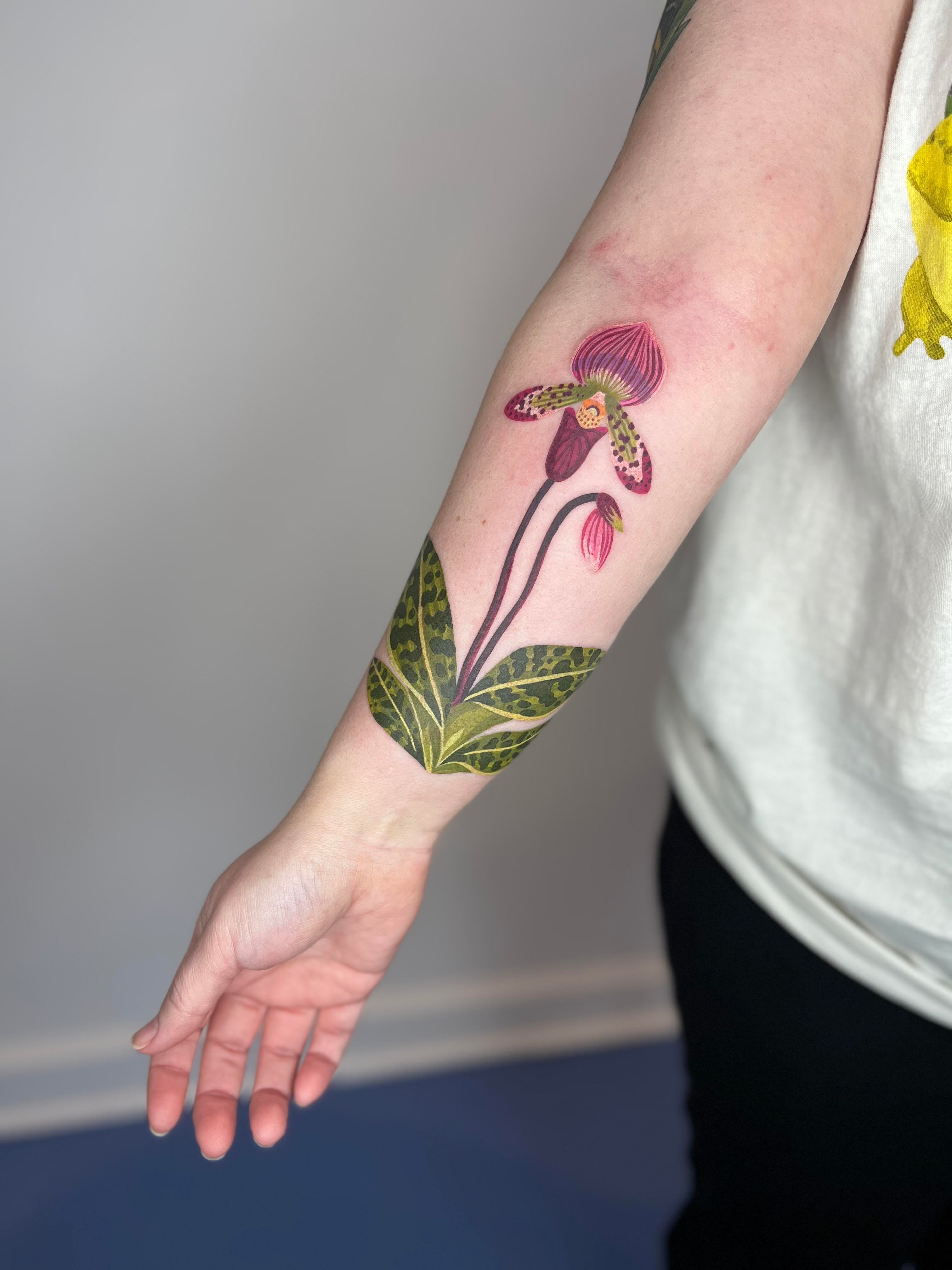 Color orchid tattoo on forearm