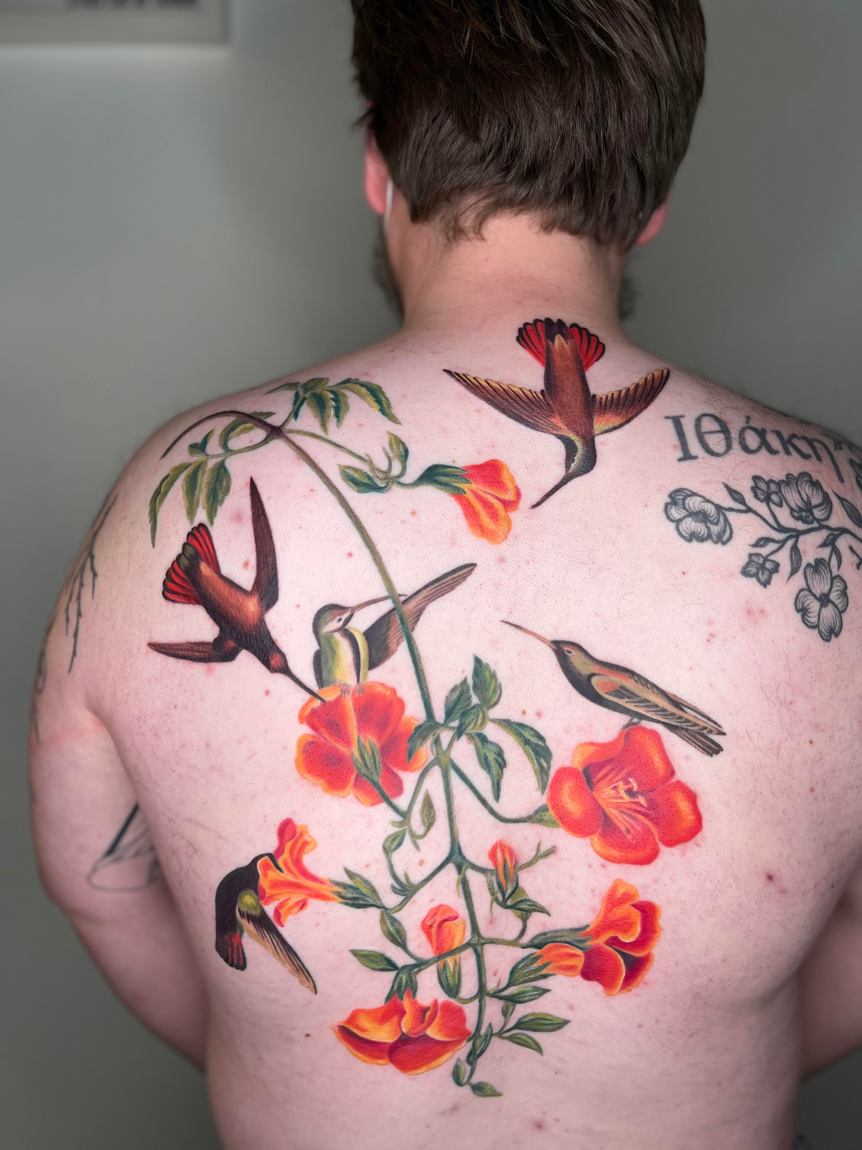 humming birds tattoo with flowers on the back